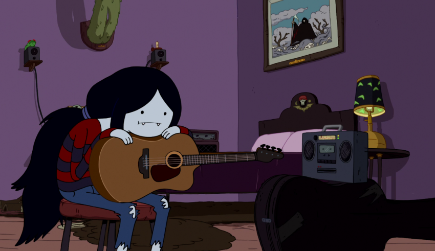 A girl with long hair is playing a guitar in a room.