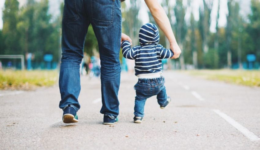 A man and a child walking down a road.