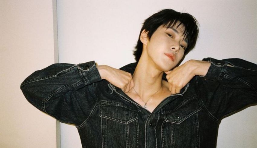 A young man posing in a denim jacket.