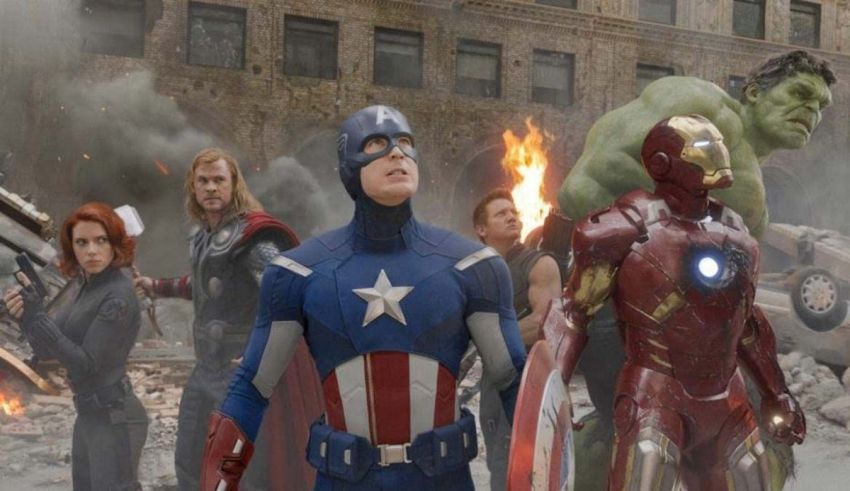 The avengers are standing in front of a city.