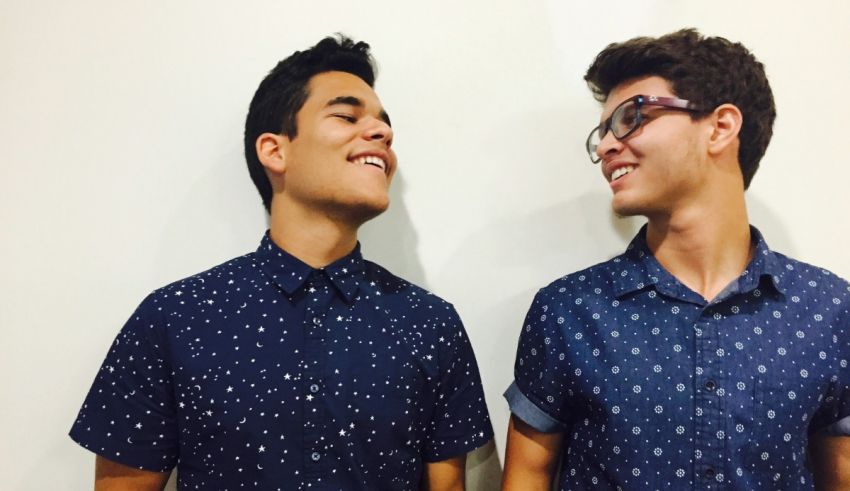 Two young men wearing polka dot shirts and smiling.
