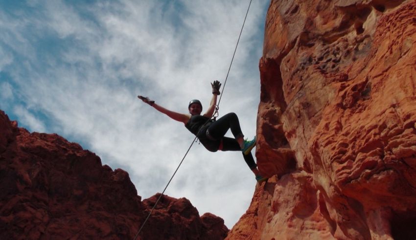A man is hanging from a rope on a cliff.