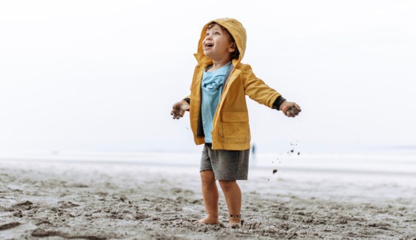 A young boy playing in the sand at the beach.