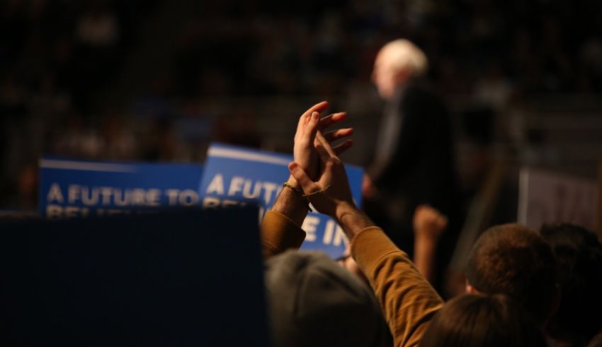 Senate candidate bernie sanders holds up his hands at a rally.