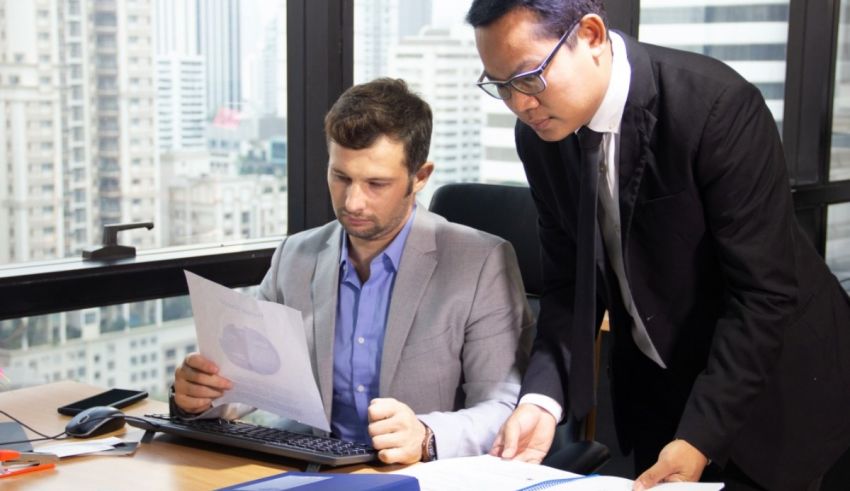 Two businessmen looking at a document in an office.