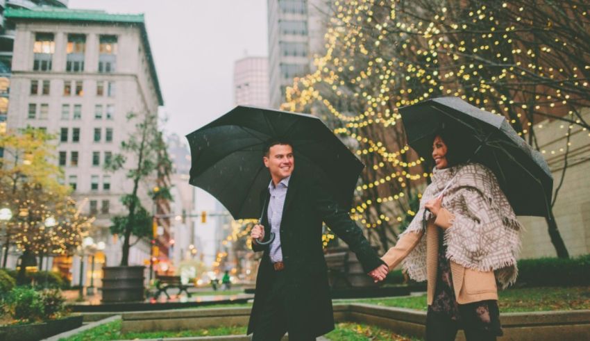 A couple holding umbrellas in the middle of a city.