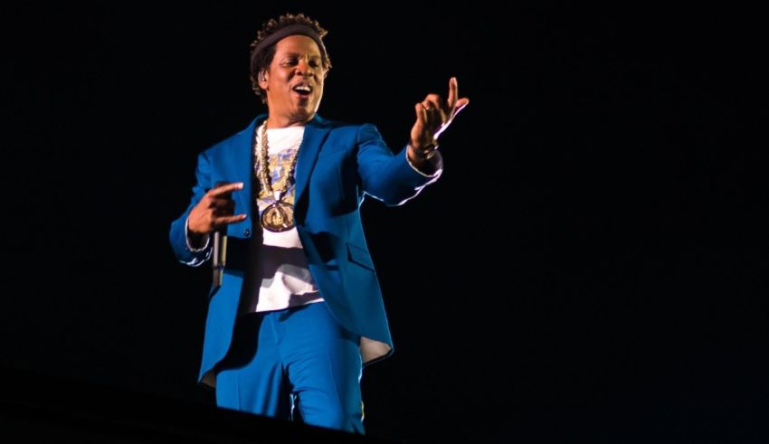 A man in a blue suit standing on top of a stage.