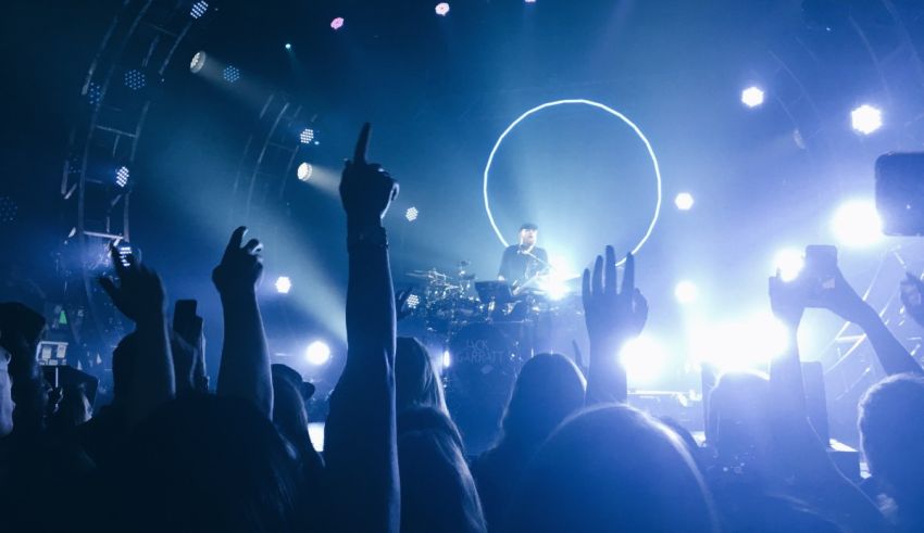 A man with his hands up at a concert.