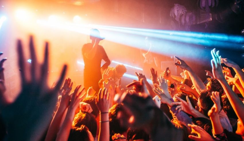 A crowd at a concert with their hands up.