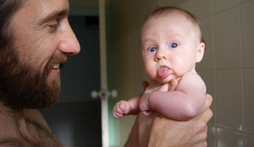 A man with a beard holding a baby.