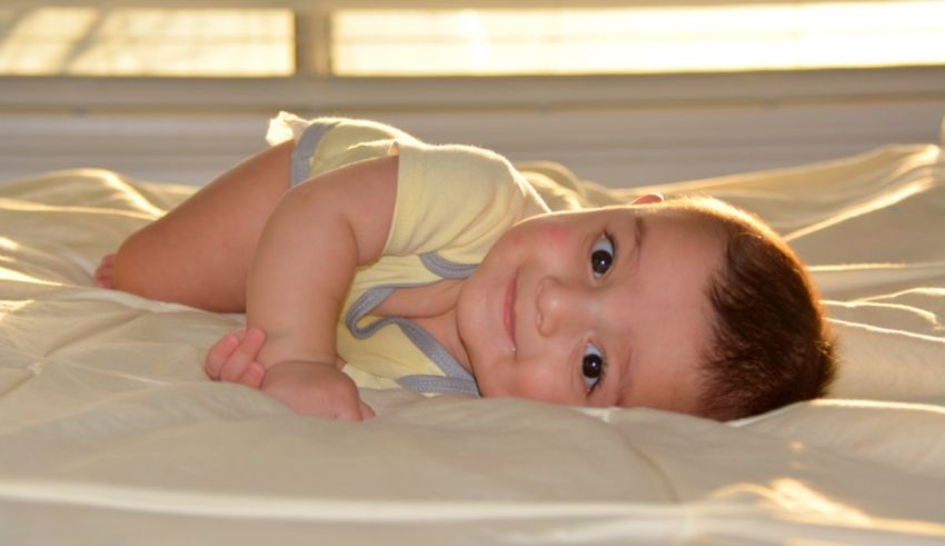 A baby laying on a bed.