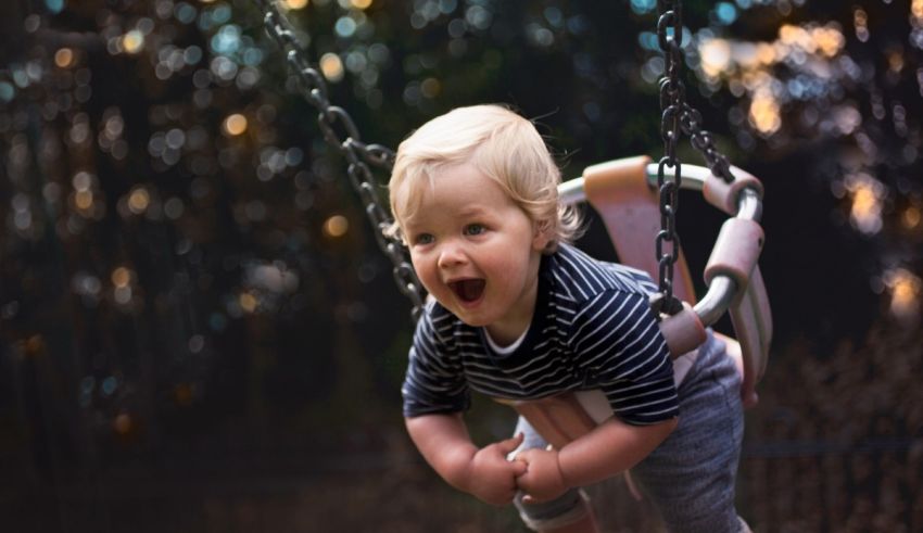 A baby is swinging on a swing.