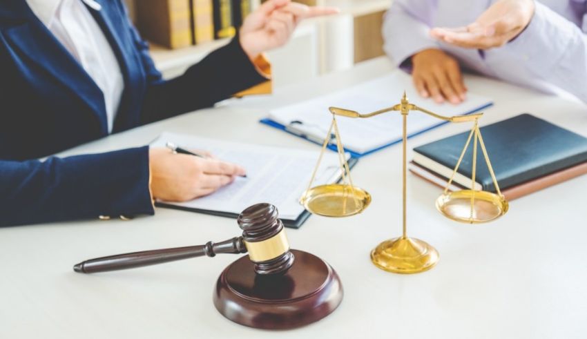 A woman and man sitting at a table with a gavel in front of them.