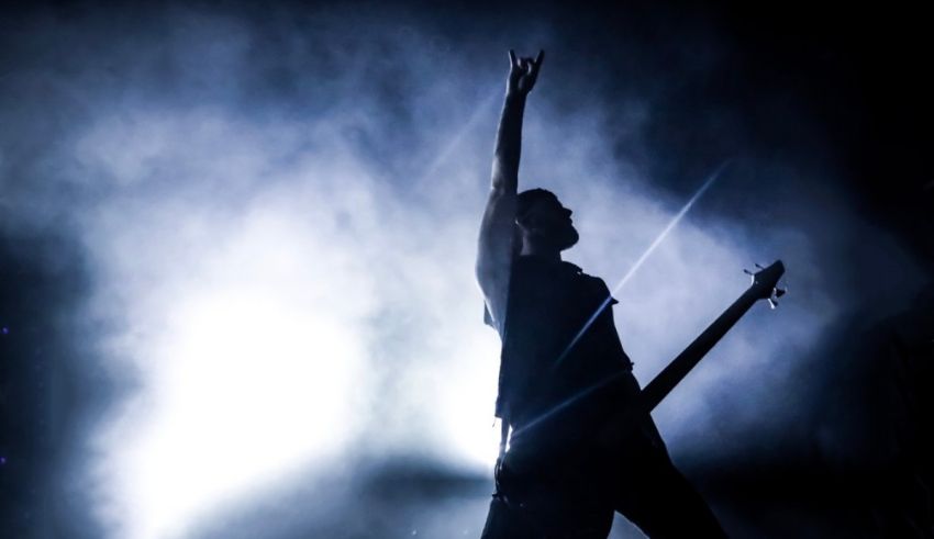 A silhouette of a man playing a bass on stage.