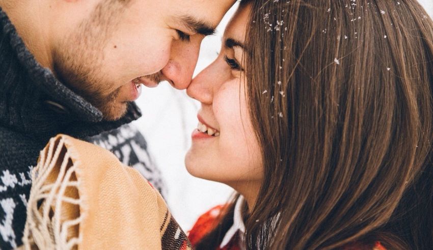 A man and woman kissing in the snow.