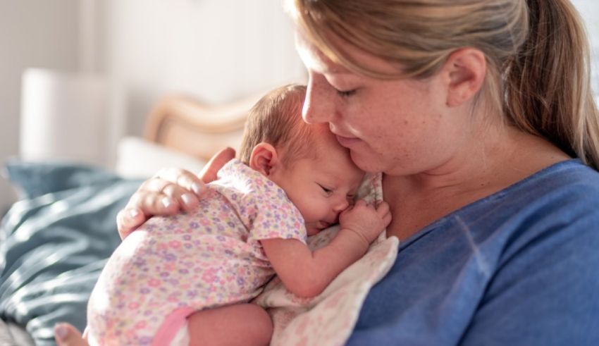 A woman is holding a baby in her arms.