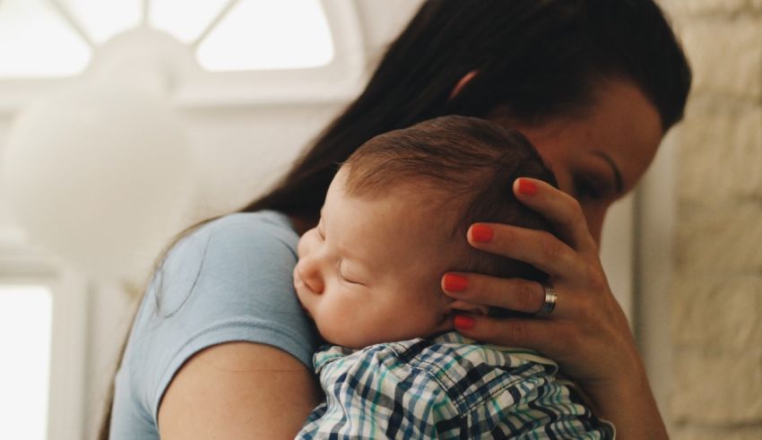 A woman is holding a baby in her arms.