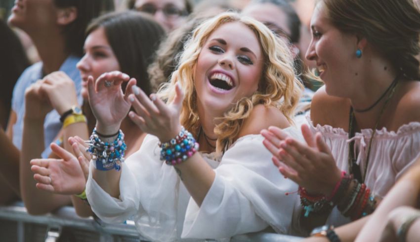 A woman is clapping at a music festival.