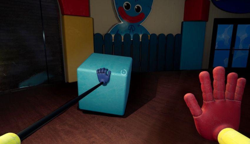 A hand is holding a blue box in a room.