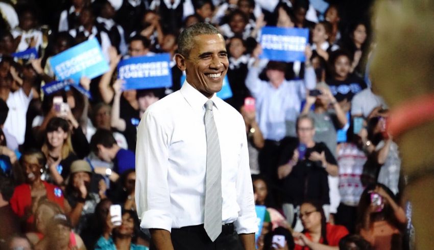 President barack obama smiles in front of a crowd.