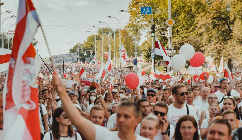 A crowd of people waving flags and balloons.