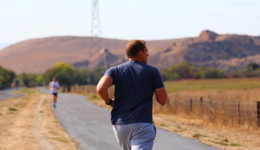 A man is jogging on a country road.