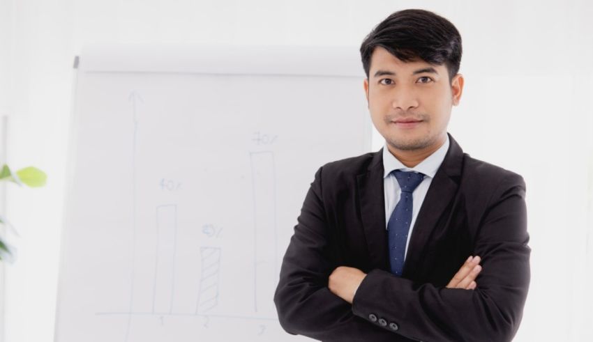 Asian businessman standing in front of a whiteboard.