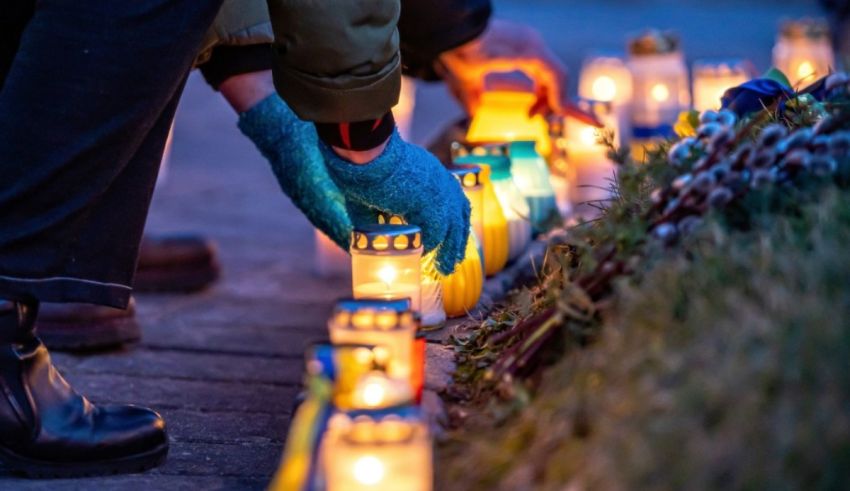 A group of people laying candles on a sidewalk.