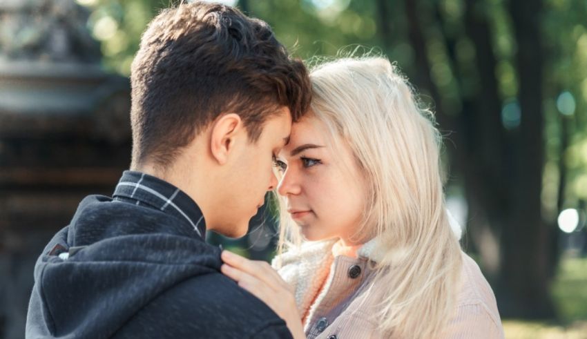 A young man and woman looking at each other in the park.
