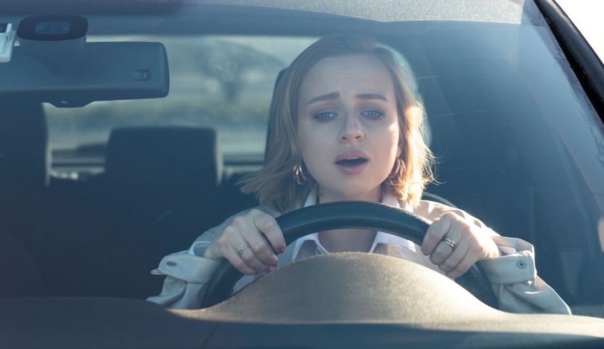 A woman driving a car with her eyes wide open.