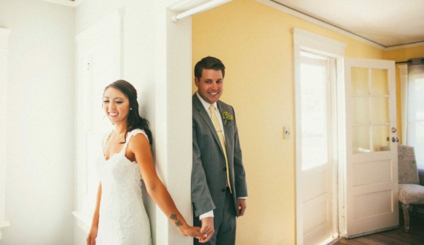 A bride and groom holding hands in a hallway.