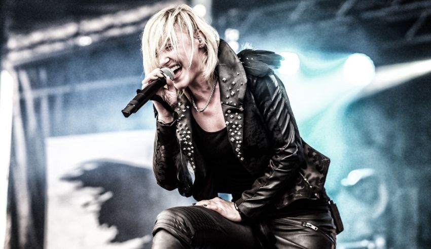 A woman in a black leather jacket singing into a microphone.