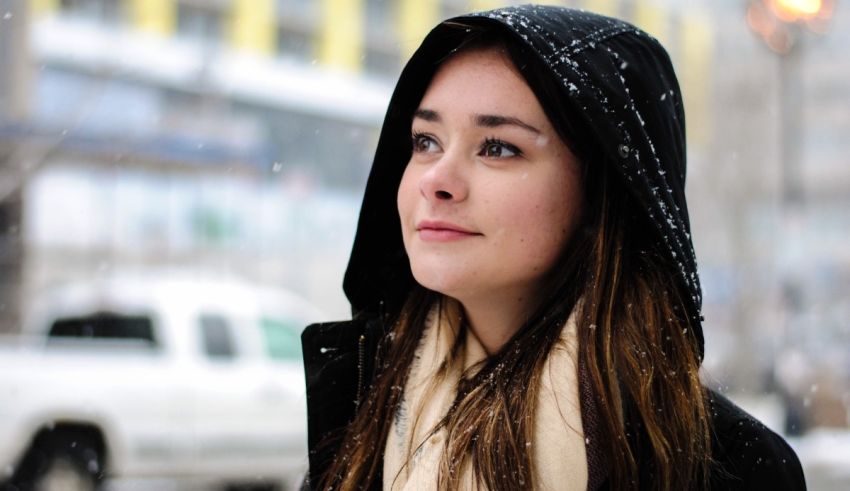 A young woman wearing a hoodie in the snow.