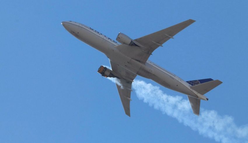 A jet airplane flying through the sky with smoke coming out of it.