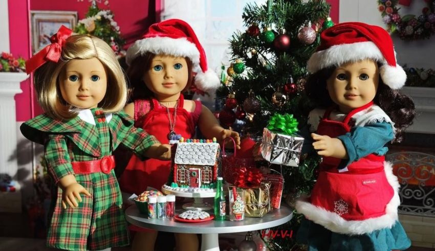 Three american girl dolls in santa hats next to a christmas tree.