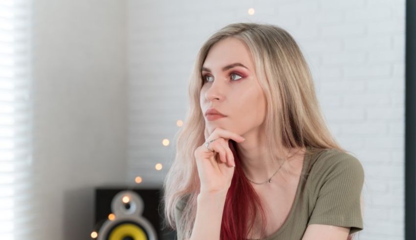 A young woman with red hair sitting in front of a speaker.