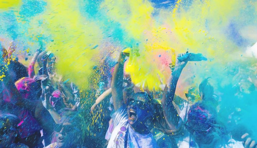 A group of people throwing colored powder in the air.