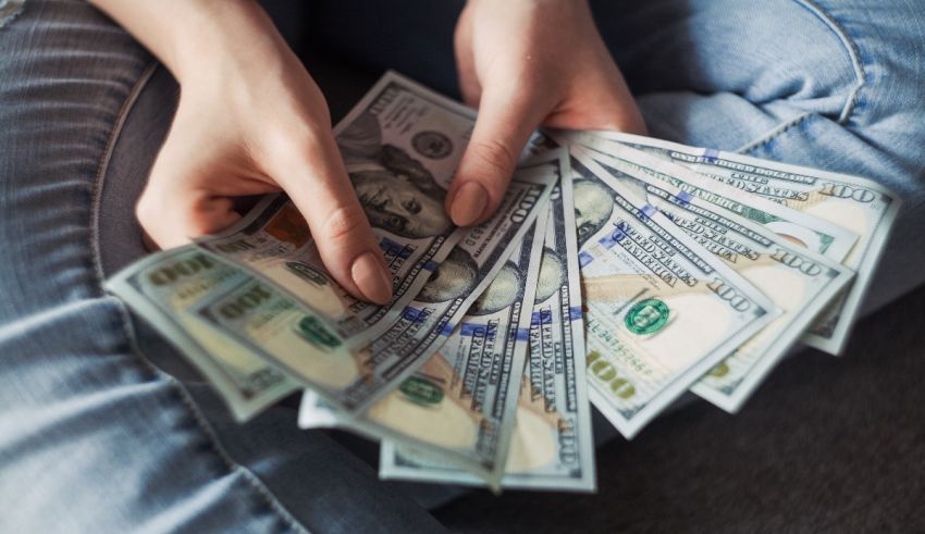 A woman is holding a bunch of cash in her hands.