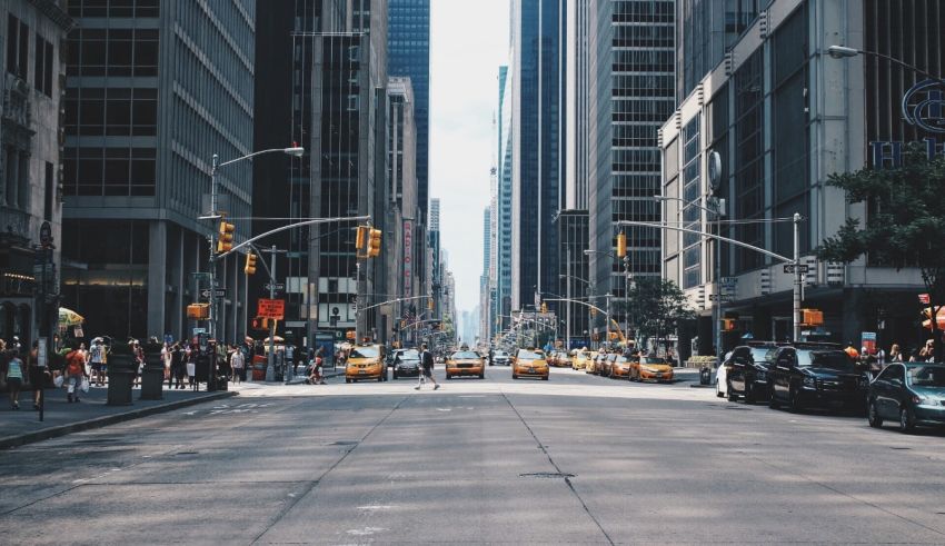 An empty street in a city with tall buildings.