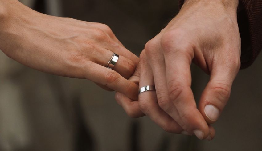 A close-up of a couple hands wearing wedding rings.