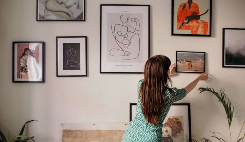 A woman looking at a picture on the wall.