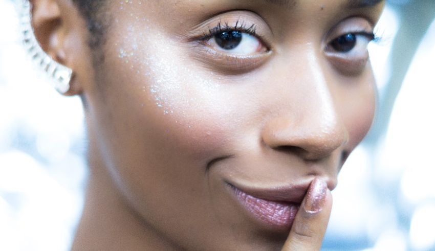 A woman is posing with her finger on her face.