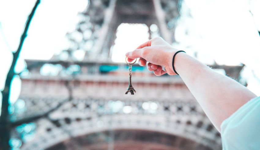 A person holding a key in front of the eiffel tower.