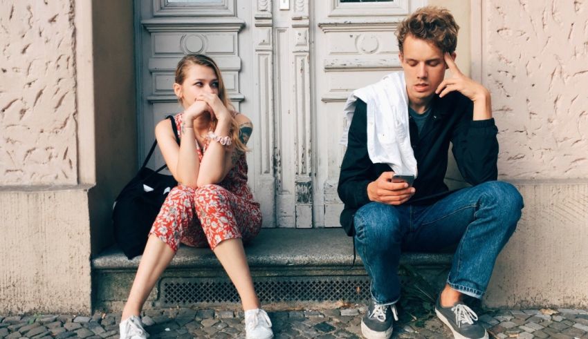 A man and woman sitting on the steps of a building.