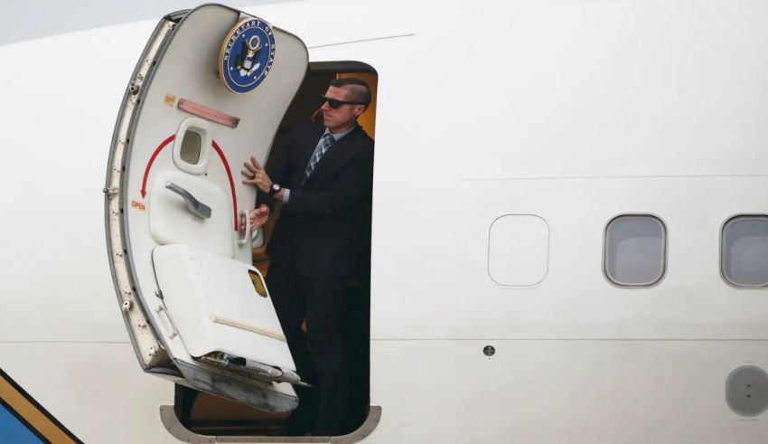 President obama exits the door of an airplane.