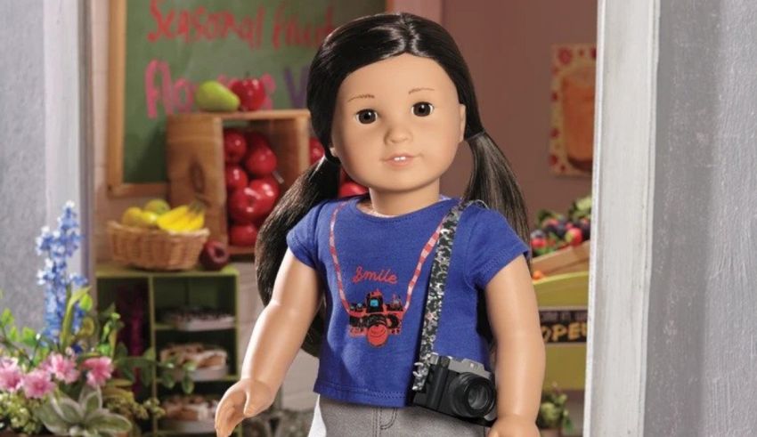 An american girl doll with a camera in her hand.