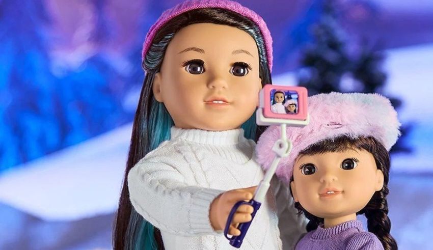Two american girl dolls are holding a selfie stick.