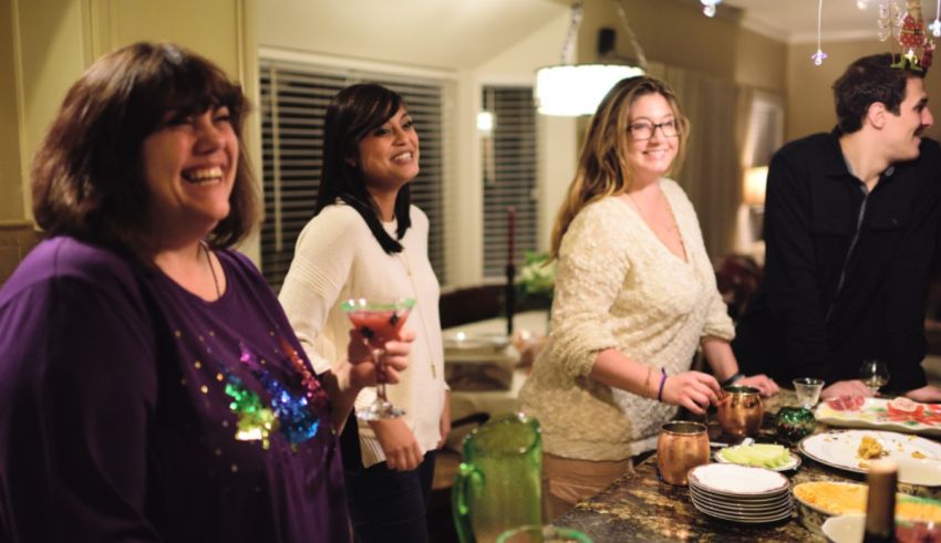 A group of people standing around a kitchen table.