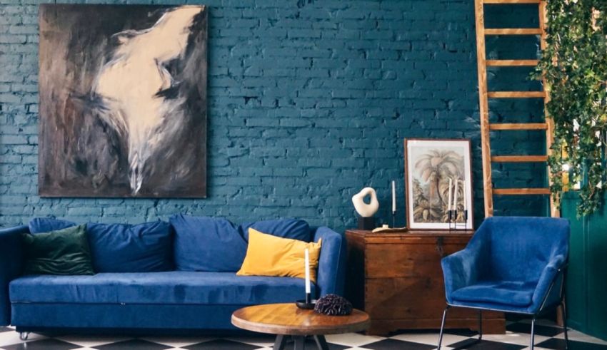 A living room with blue walls and a blue sofa.