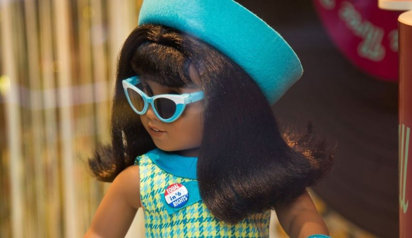 A doll with a hat and sunglasses in a window display.